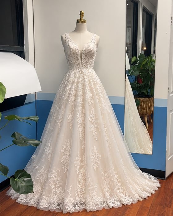 A lace wedding gown on a dress form in the shop.